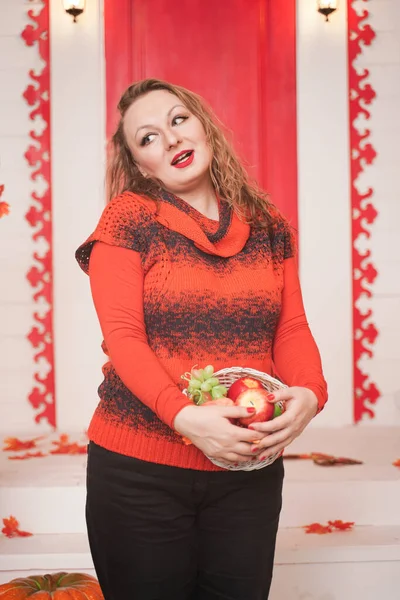 Bela mulher gordinha emocional caucasiano com maçãs em pequena cesta no fundo da casa branca sozinho — Fotografia de Stock