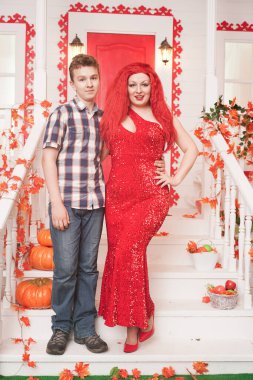 Anne ve oğul sonbahar partisine gitmeye ve beyaz evlerinin verandasında poz vermeye hazırlar.