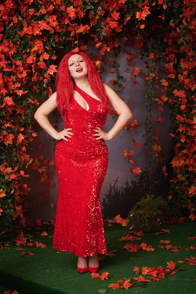 Bela menina gorda em vestido de noite longo vermelho no parque de outono. corpo de comprimento total . — Fotografia de Stock