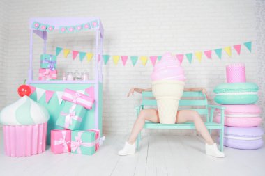 Beyaz şortlu ve şık kısa elbiseli güzel fitness kızı odanın arka planında kocaman yapay yemek tatlılarıyla poz veriyor. Diyet yaparken yemekle oynayan neşeli, ince bir kadın..