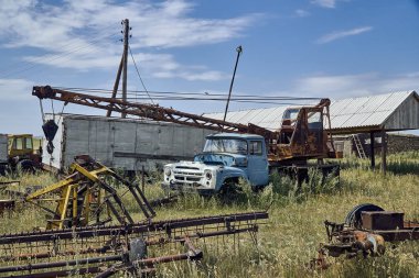 The old Soviet auto and agricultural machinery abandoned in the steppe not far from Sartymbet village, stone mountains 