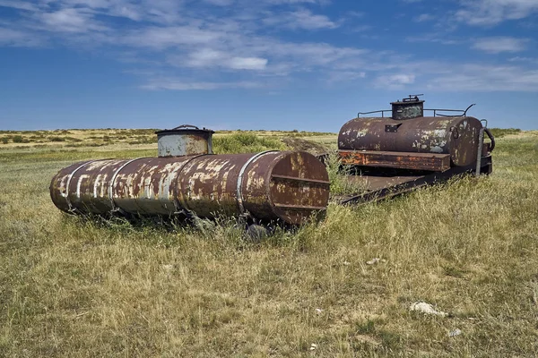 The old Soviet auto and agricultural machinery abandoned in the steppe not far from Sartymbet village, stone mountains \