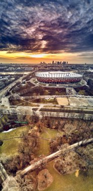 Varşova gökdelen ile modern şehir ve Pge Narodowy Ulusal Stadyumu güzel panoramik hava dron görünümüne (Lehçe: Stadion Narodowy) dramatik bir gün batımı arka planı