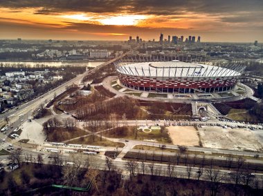 Varşova gökdelen ile modern şehir ve Pge Narodowy Ulusal Stadyumu güzel panoramik hava dron görünümüne (Lehçe: Stadion Narodowy) dramatik bir gün batımı arka planı