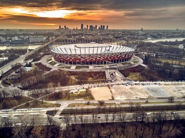 Varşova gökdelen ile modern şehir ve Pge Narodowy Ulusal Stadyumu güzel panoramik hava dron görünümüne (Lehçe: Stadion Narodowy) dramatik bir gün batımı arka planı