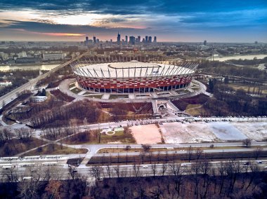 Varşova gökdelen ile modern şehir ve Pge Narodowy Ulusal Stadyumu güzel panoramik hava dron görünümüne (Lehçe: Stadion Narodowy) dramatik bir gün batımı arka planı