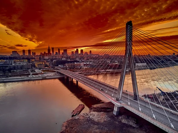 Bela vista panorâmica do pôr-do-sol do drone aéreo para o centro da cidade de Varsóvia com arranha-céus e a ponte Swietokrzyski (En: Holy Cross Bridge) é uma ponte suspensa por cabo sobre o rio Vístula em Varsóvia, Polônia — Fotografia de Stock