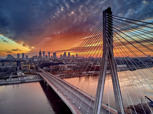 Bela vista panorâmica do pôr-do-sol do drone aéreo para o centro da cidade de Varsóvia com arranha-céus e a ponte Swietokrzyski (En: Holy Cross Bridge) é uma ponte suspensa por cabo sobre o rio Vístula em Varsóvia, Polônia — Fotografia de Stock