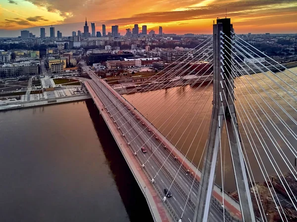 Bela vista panorâmica do pôr-do-sol do drone aéreo para o centro da cidade de Varsóvia com arranha-céus e a ponte Swietokrzyski (En: Holy Cross Bridge) é uma ponte suspensa por cabo sobre o rio Vístula em Varsóvia, Polônia — Fotografia de Stock