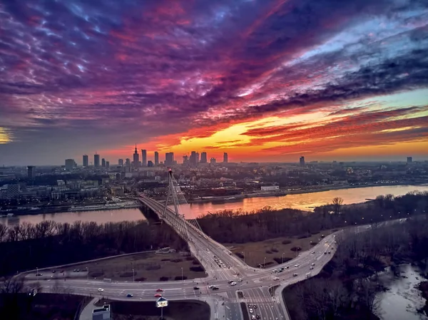 Bela vista panorâmica do pôr-do-sol do drone aéreo para o centro da cidade de Varsóvia com arranha-céus e a ponte Swietokrzyski (En: Holy Cross Bridge) é uma ponte suspensa por cabo sobre o rio Vístula em Varsóvia, Polônia — Fotografia de Stock