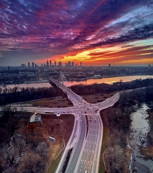 Bela vista panorâmica do pôr-do-sol do drone aéreo para o centro da cidade de Varsóvia com arranha-céus e a ponte Swietokrzyski (En: Holy Cross Bridge) é uma ponte suspensa por cabo sobre o rio Vístula em Varsóvia, Polônia — Fotografia de Stock