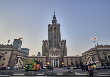 WARSAW, POLAND - APRIL 07, 2019: Beautiful evening wide-angle panoramic view from the street to iew of the Palace of Culture and Science (PKiN) - the largest symbol and the tallest building in Warsaw clipart