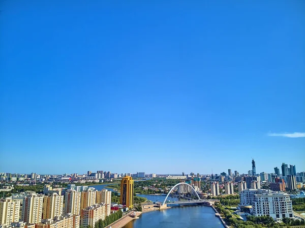 NUR-SULTAN, KAZAKHSTAN - 30 de julho: Bela vista panorâmica de drones aéreos para o Ishim River Embankment??? Nur-Sultan ou Nursultan (Astana) centro da cidade com arranha-céus e ponte pedonal moderna — Fotografia de Stock