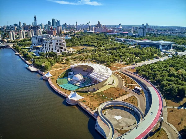 NUR-SULTAN, KAZAKHSTAN - 30 de julho: Bela vista panorâmica de drones aéreos para o Ishim River Embankment??? Nur-Sultan ou Nursultan (Astana) centro da cidade com arranha-céus e ponte pedonal moderna — Fotografia de Stock