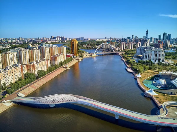 Nur-Sultan, Kazakistan - 30 Temmuz: Ishim Nehri Embankment 'e güzel panoramik hava aracı manzarası Gökdelenleri ve modern yaya köprüsü olan Nur-Sultan (Astana) şehir merkezi