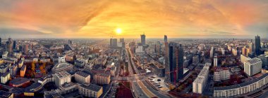 Varşova Modern Şehri, Mennica Miras Kulesi (140m) ofis gökdeleni ve Varşova Spire 'ın panorama şehir manzarasına güzel panoramik hava aracı görüntüsü, sonbaharda gün batımında, Varşova, Polonya