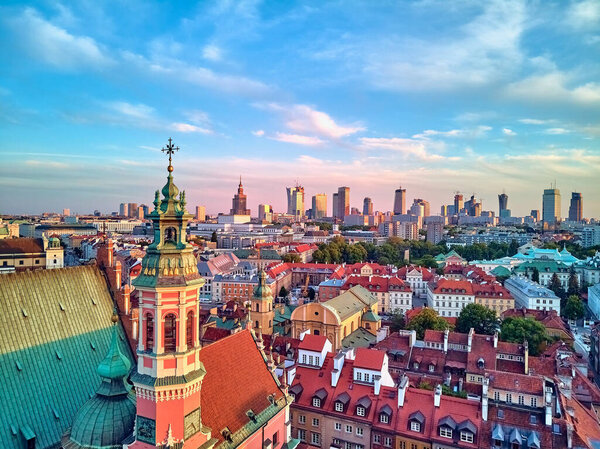 Beautiful panoramic aerial drone view on Warsaw Old town (POL: Stare Miasto) with modern skyscrapers on the horizon, Royal Castle, square and the Column of Sigismund III Vasa at sunset, Poland.