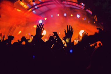 Soyut bulanık atmosfer: açık hava müzik festivali konserinden hoşlanan mutlu insanlar, el kaldırdılar ve zevk alkışladılar, aktif gece hayatı konsepti, büyük sahnede ışık ve gölge oyunu