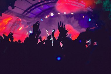 Soyut bulanık atmosfer: açık hava müzik festivali konserinden hoşlanan mutlu insanlar, el kaldırdılar ve zevk alkışladılar, aktif gece hayatı konsepti, büyük sahnede ışık ve gölge oyunu