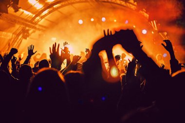 Soyut bulanık atmosfer: açık hava müzik festivali konserinden hoşlanan mutlu insanlar, el kaldırdılar ve zevk alkışladılar, aktif gece hayatı konsepti, büyük sahnede ışık ve gölge oyunu
