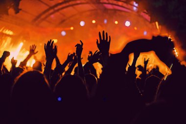 Soyut bulanık atmosfer: açık hava müzik festivali konserinden hoşlanan mutlu insanlar, el kaldırdılar ve zevk alkışladılar, aktif gece hayatı konsepti, büyük sahnede ışık ve gölge oyunu