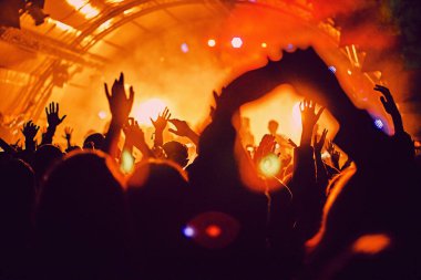 Soyut bulanık atmosfer: açık hava müzik festivali konserinden hoşlanan mutlu insanlar, el kaldırdılar ve zevk alkışladılar, aktif gece hayatı konsepti, büyük sahnede ışık ve gölge oyunu
