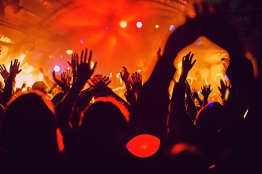 Soyut bulanık atmosfer: açık hava müzik festivali konserinden hoşlanan mutlu insanlar, el kaldırdılar ve zevk alkışladılar, aktif gece hayatı konsepti, büyük sahnede ışık ve gölge oyunu