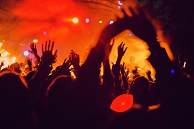 Soyut bulanık atmosfer: açık hava müzik festivali konserinden hoşlanan mutlu insanlar, el kaldırdılar ve zevk alkışladılar, aktif gece hayatı konsepti, büyük sahnede ışık ve gölge oyunu