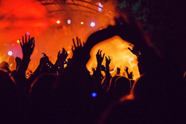 Soyut bulanık atmosfer: açık hava müzik festivali konserinden hoşlanan mutlu insanlar, el kaldırdılar ve zevk alkışladılar, aktif gece hayatı konsepti, büyük sahnede ışık ve gölge oyunu