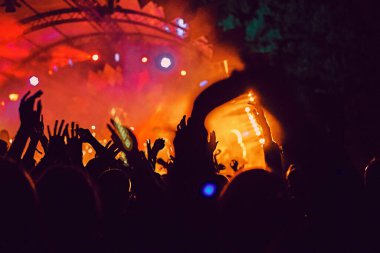 Soyut bulanık atmosfer: açık hava müzik festivali konserinden hoşlanan mutlu insanlar, el kaldırdılar ve zevk alkışladılar, aktif gece hayatı konsepti, büyük sahnede ışık ve gölge oyunu