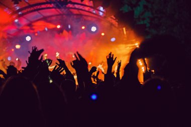 Soyut bulanık atmosfer: açık hava müzik festivali konserinden hoşlanan mutlu insanlar, el kaldırdılar ve zevk alkışladılar, aktif gece hayatı konsepti, büyük sahnede ışık ve gölge oyunu