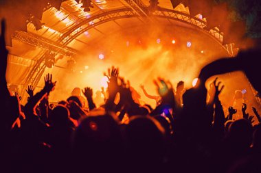 Soyut bulanık atmosfer: açık hava müzik festivali konserinden hoşlanan mutlu insanlar, el kaldırdılar ve zevk alkışladılar, aktif gece hayatı konsepti, büyük sahnede ışık ve gölge oyunu