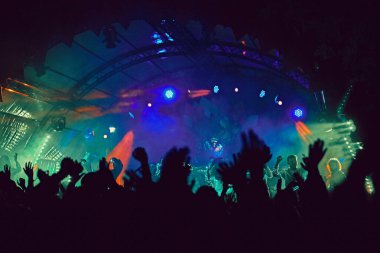 Soyut bulanık atmosfer: açık hava müzik festivali konserinden hoşlanan mutlu insanlar, el kaldırdılar ve zevk alkışladılar, aktif gece hayatı konsepti, büyük sahnede ışık ve gölge oyunu