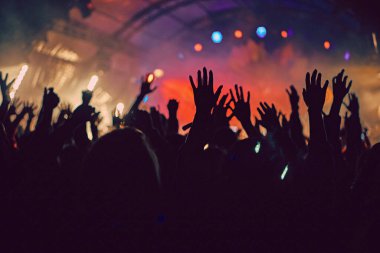 Soyut bulanık atmosfer: açık hava müzik festivali konserinden hoşlanan mutlu insanlar, el kaldırdılar ve zevk alkışladılar, aktif gece hayatı konsepti, büyük sahnede ışık ve gölge oyunu