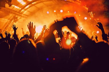 Soyut bulanık atmosfer: açık hava müzik festivali konserinden hoşlanan mutlu insanlar, el kaldırdılar ve zevk alkışladılar, aktif gece hayatı konsepti, büyük sahnede ışık ve gölge oyunu