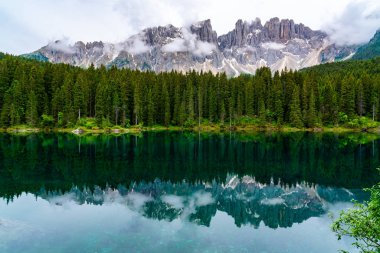 Güzel göl Carezza manzarası ile ünlü Dağı Latemar ve Güney Tirol bölgesinin İtalya, çam ağaçları orman yansımasıdır