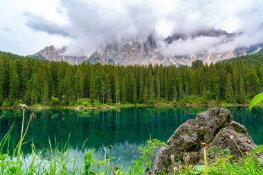 Güzel gökkuşağı göl Carezza çam ağaçları ve Mount Latemar orman içinde belgili tanımlık geçmiş