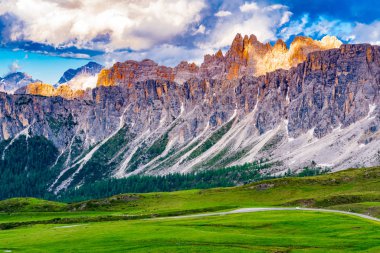 Akşam ışığı ile Giau Pass İtalya güzel Dolomites dağ görünümü üzerinde tepe ve yol geç çimenli alan git