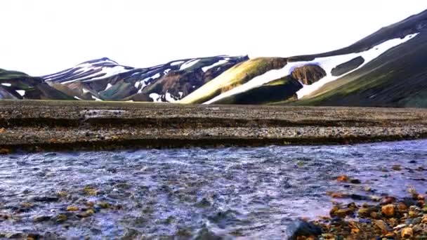 夕方にはハイランドのアイスランドの美しい山々 を流れる雪解けのストリーム — ストック動画
