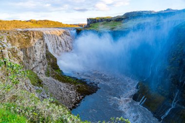 İzlanda'daki sis ve su sprey ile sabah güneş ışığı altında Dettifoss şelale görünümünü