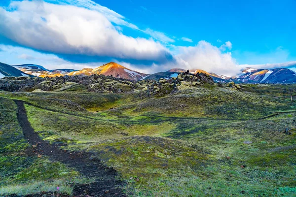 令人印象深刻的阳光照耀在美丽的山的顶部与岩石领域的花卉在早晨在兰德曼纳劳卡在冰岛高地 — 图库照片