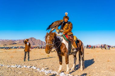 Ulgii, Moğolistan - 6 Ekim 2018: altın kartal Festivali. Altın kartal avcı portre geleneği giyim ile kartal Ulgii Moğolistan'da rekabet sitesinde onun elinde 6 Ekim 2018