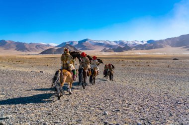 Golden Eagle Festivali rekabet sitesinde Ulgii Moğolistan'horseback Binicilik geleneği giysili Moğol kartal avcı