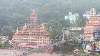 Rishikesh, Hindistan - 15 Ağustos 2014: Titreme tapınak Rishikesh Hindistan'da Ganj Nehri yağmurlu günde sadık Jhula köprüden ile
