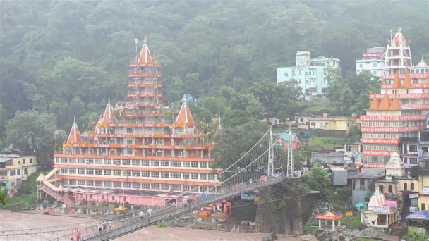雨の日にガンジス川に架かるラクシュマン ジューラ橋とリシケシ インドのリシケシ インド 2014 シヴァ寺院 — ストック動画