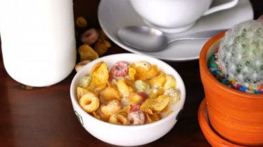 Scooping ve üzerinden bir kahvaltı olarak beyaz bir kase tahıl Mısır gevreği ve Froot Loops yeme