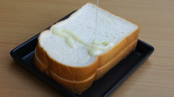 Pouring Condensed Milk Sliced Bread Black Plate — Stock Video