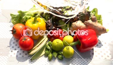 Ağır çekimde masada karışık sebze yığını için tatlı su dökme