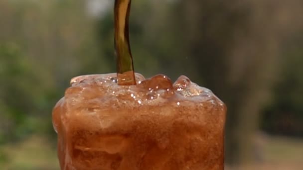 在慢动作中 将软饮料倒进装满冰块的玻璃中 — 图库视频影像