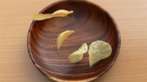 Potato Chips Vallen Een Houten Plaat Een Tafel Slow Motion — Stockvideo